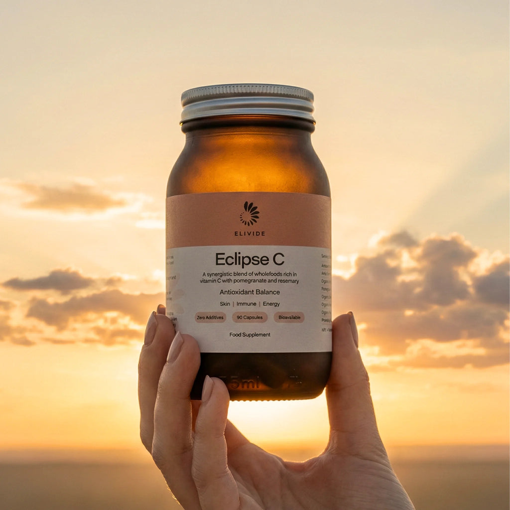 ELIVIDE Eclipse wholefood vitamin C supplement bottle held at sunset